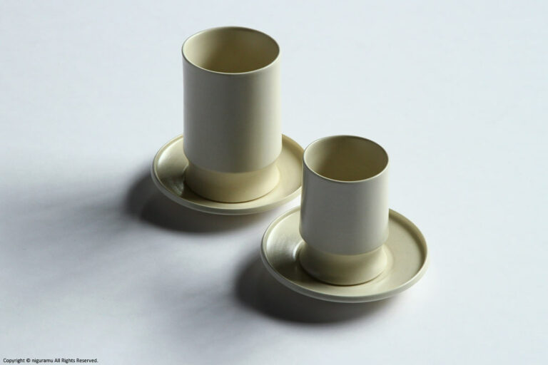 Une, Cup and tumbler on saucers.